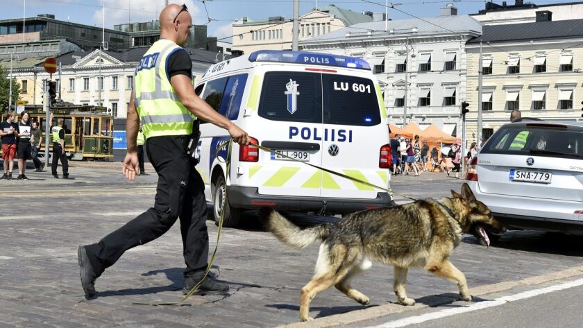 A police officer patrols with his dog at the Helsinki Market Square in Helsinki, Finland, on July 14, 2018.