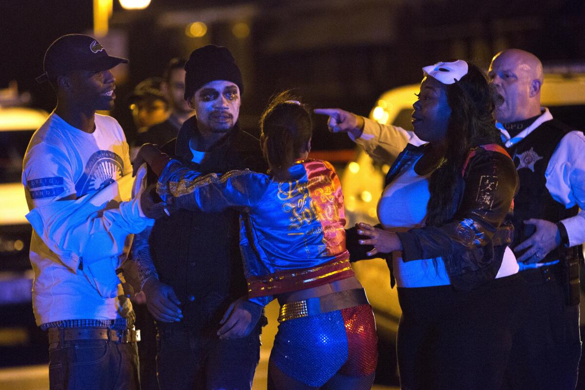 A Chicago police officer tells several people dressed in costume to leave the scene of a shooting late Saturday.