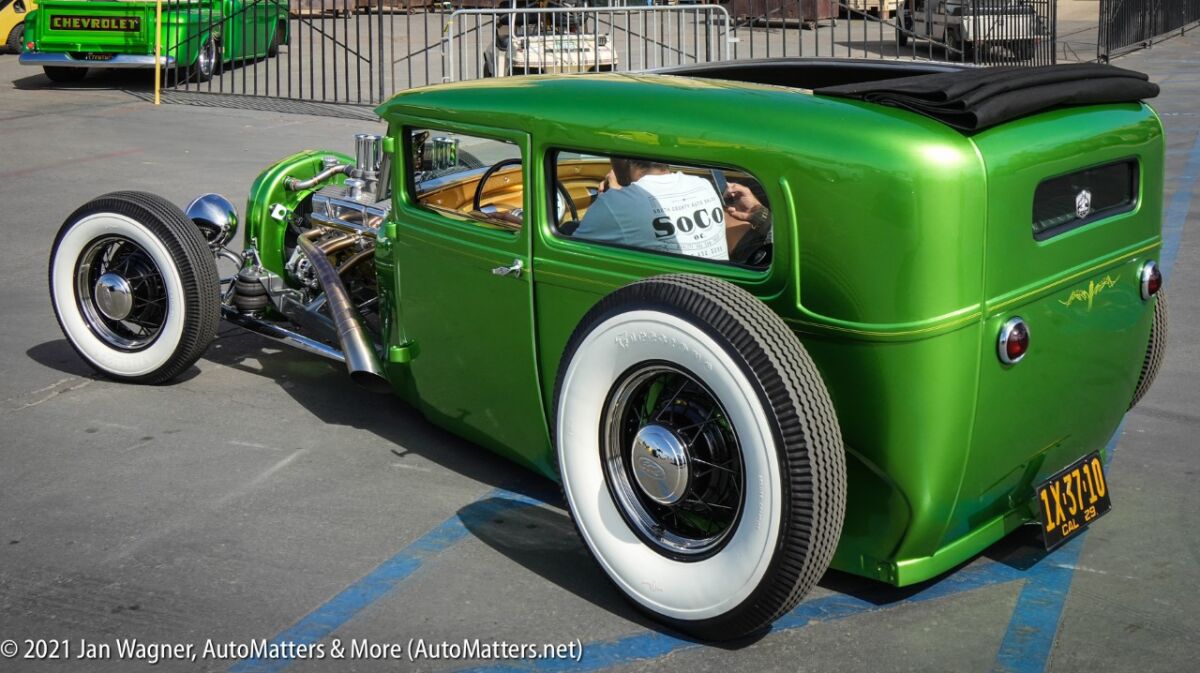 Green custom car with huge rear tires.