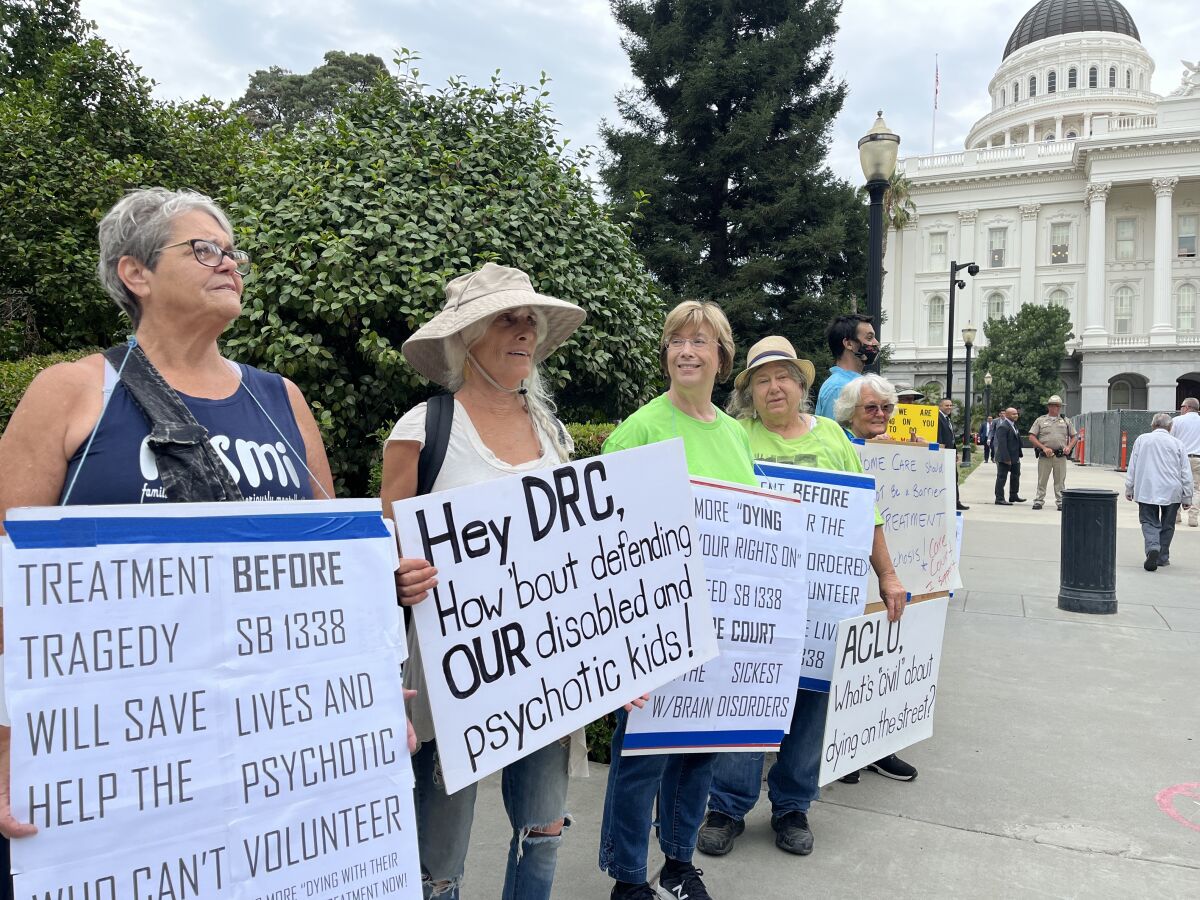 Demonstrators at the Capitol hold signs reading "Treatment Before Tragedy" and more.