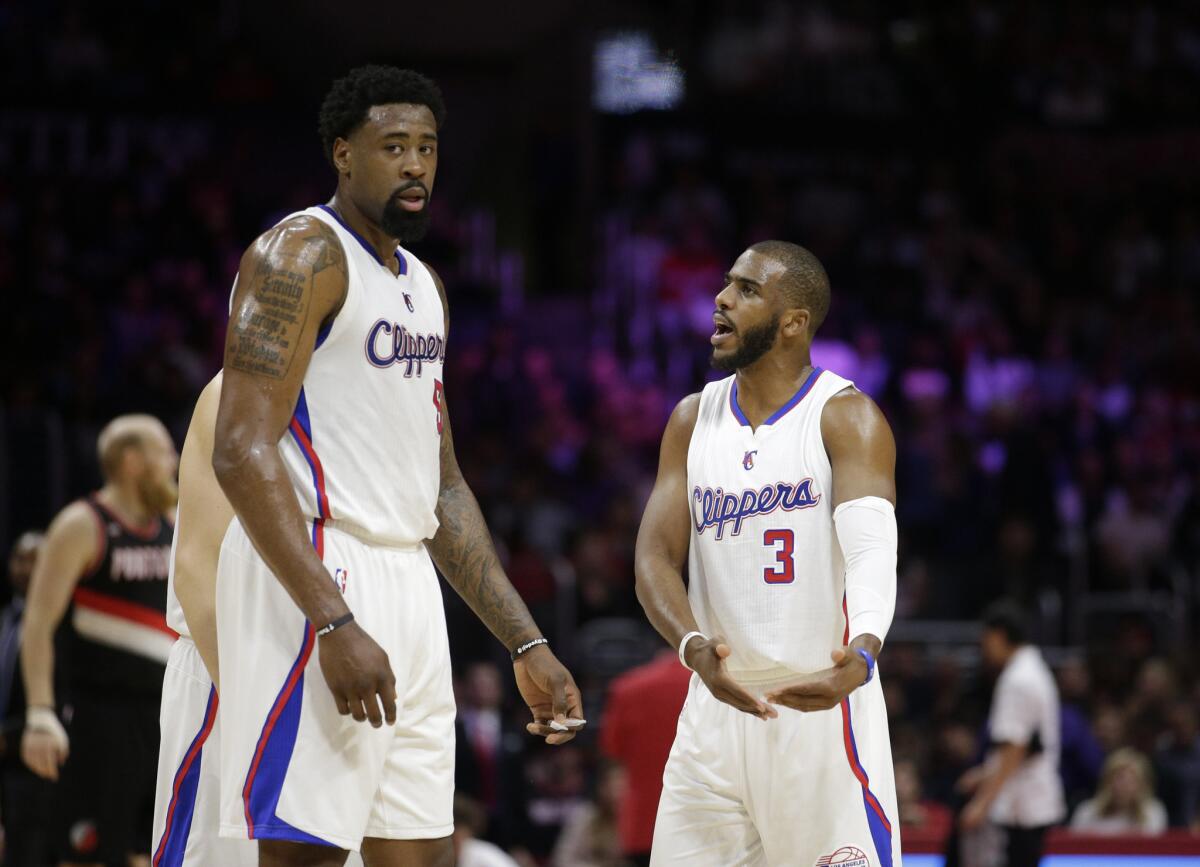 Clippers guard Chris Paul talks to center DeAndre Jordan during the 98-93 overtime loss to the Trail Blazers.