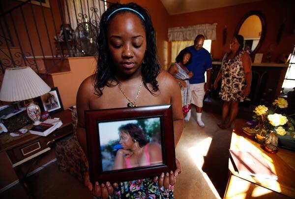 Khristina Henry holds a photo of her mother, Pamela Lark. Lark adamantly wanted her daughter to testify in the robbery trial of a former high school football star accused of robbing Henry and a friend at gunpoint.