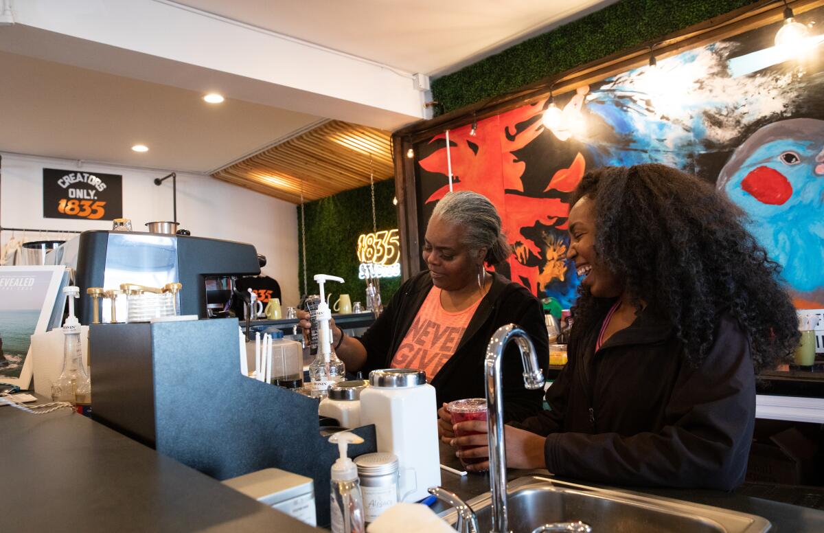 Mother-and-daughter entrepreneurs Cynthia Ajani, left, and Khea Pollard mix drinks at Cafe X: By Any Beans Necessary.