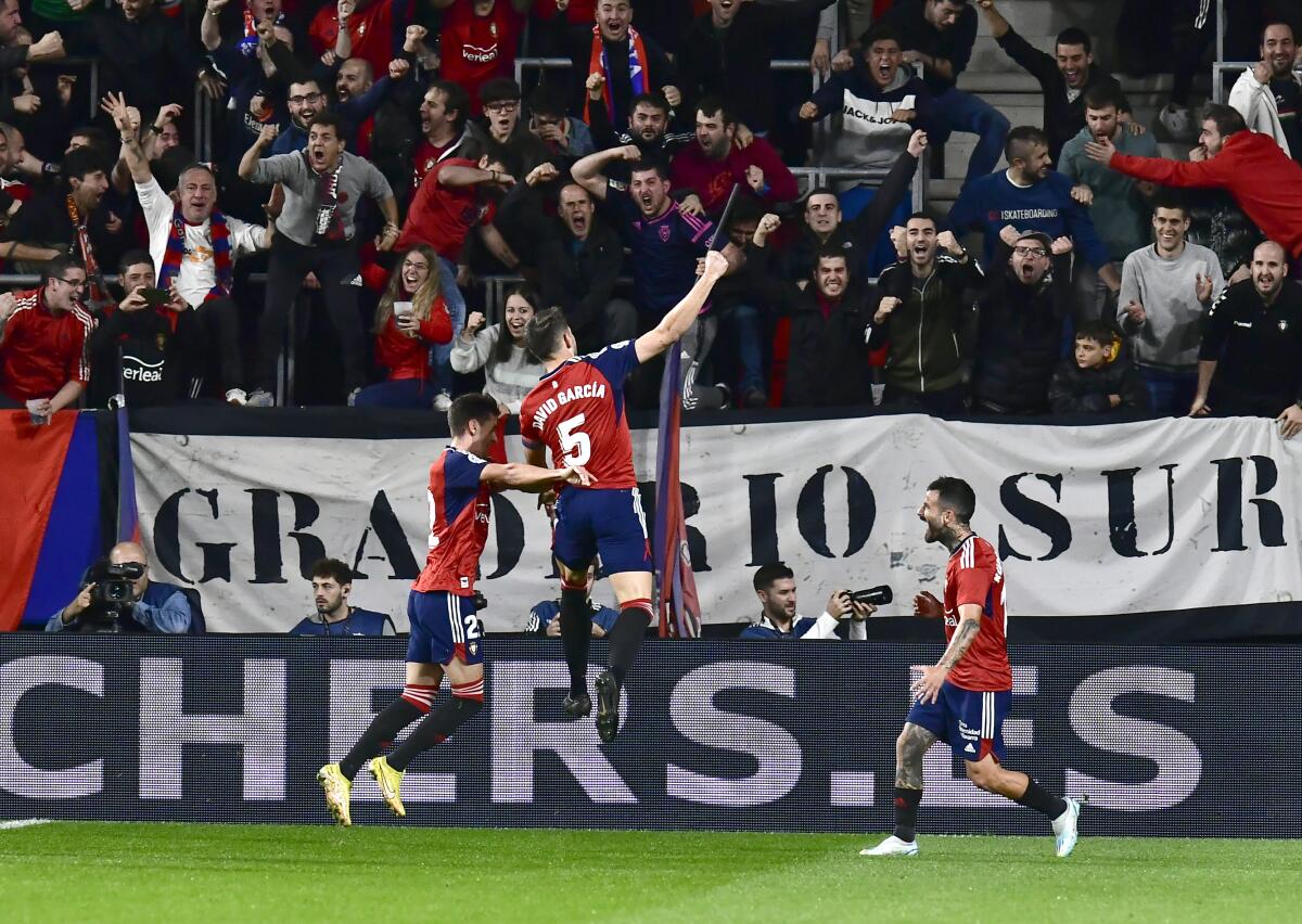 Osasuna's David Garcia celebrates in front of supporters after scoring during a La Liga match against Barcelona