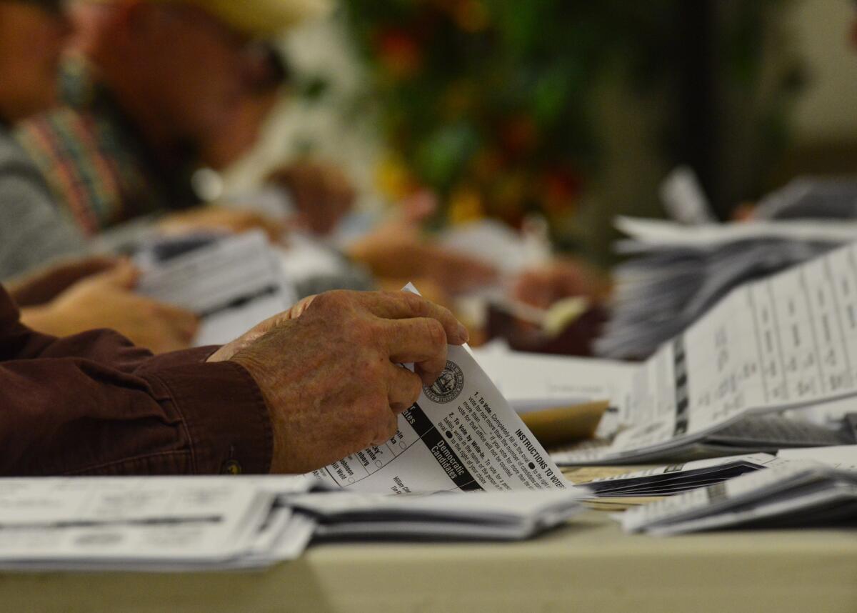 Ballot counters at the Hinsdale, N.H., polling station hand count ballots on Tuesday.