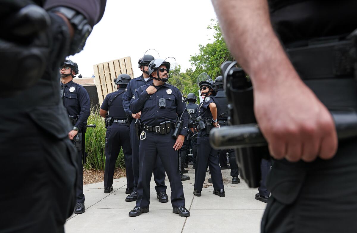 Police in uniform, framed by two officers, standing guard at UCLA
