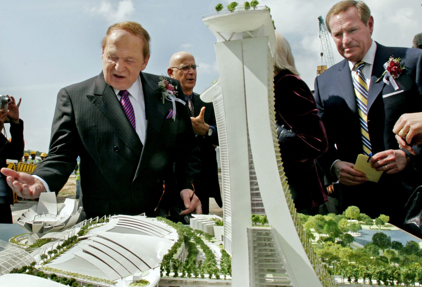 Sheldon Adelson and others look at a model of a resort.