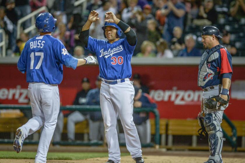 Miguel Olivo (30) of Albuquerque congratulates Nick Buss after Buss' homer against the Tacoma Rainiers.