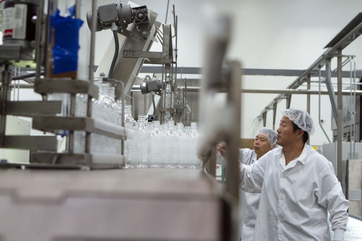 Wei Wang and Wei Zhang work in the packaging area at Huy Fong Foods Inc. in Irwindale.