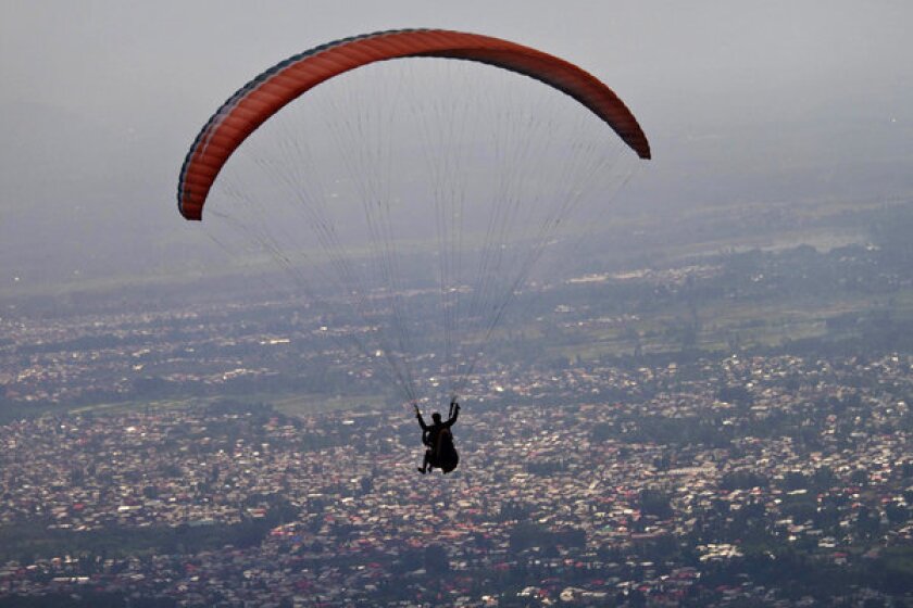 Iranian authorities have accused several visiting Slovaks of using paragliders to spy on Iranian defense installations. Above, a file photo shows paraglider on the outskirts of Srinagar, India.