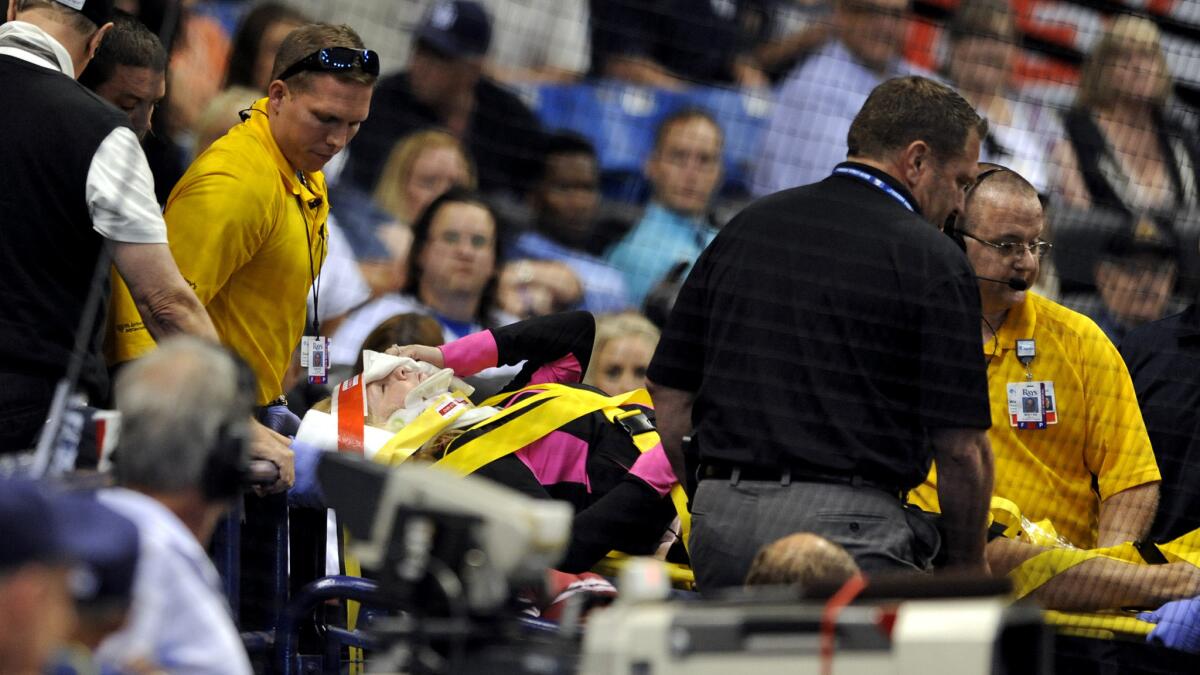 Medical personnel carry a fan from the stands by stretcher after she was struck by a foul ball from hit by Rays designated hitter Steven Souza Jr. during the seventh inning Friday.
