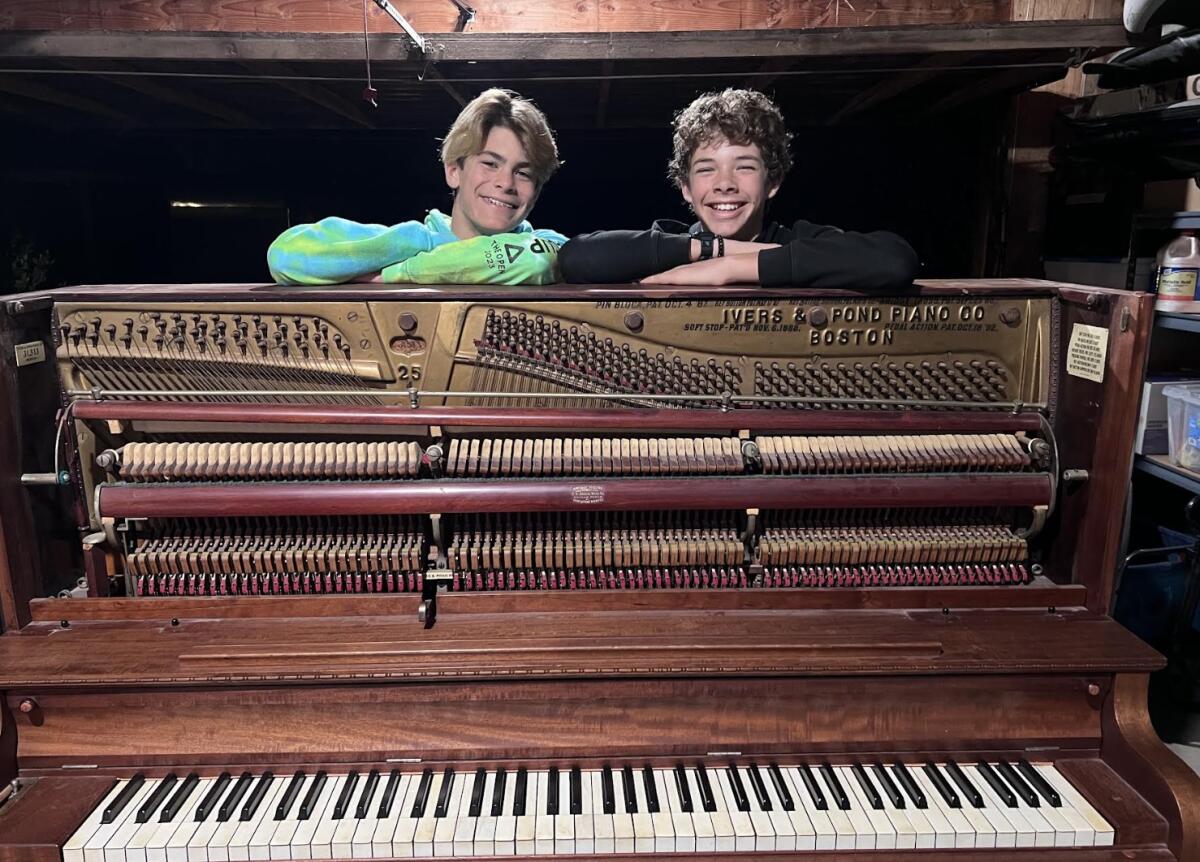 Liam Koett (left) and Makena Stumpo show the piano they later turned into an artwork.