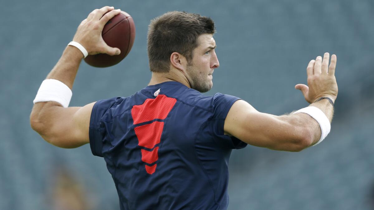 Tim Tebow warms up before a preseason game between the New England Patriots and Philadelphia Eagles in August 2013.
