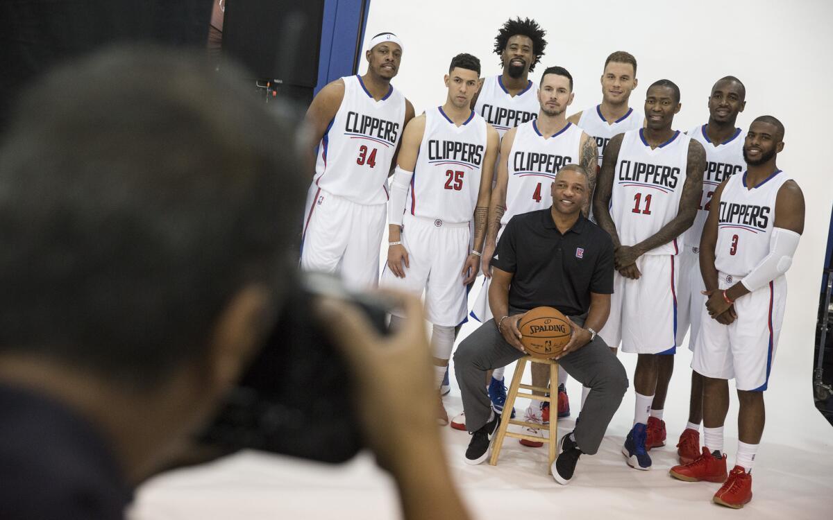 Coach Doc Rivers, sitting, and the Clippers at media day.