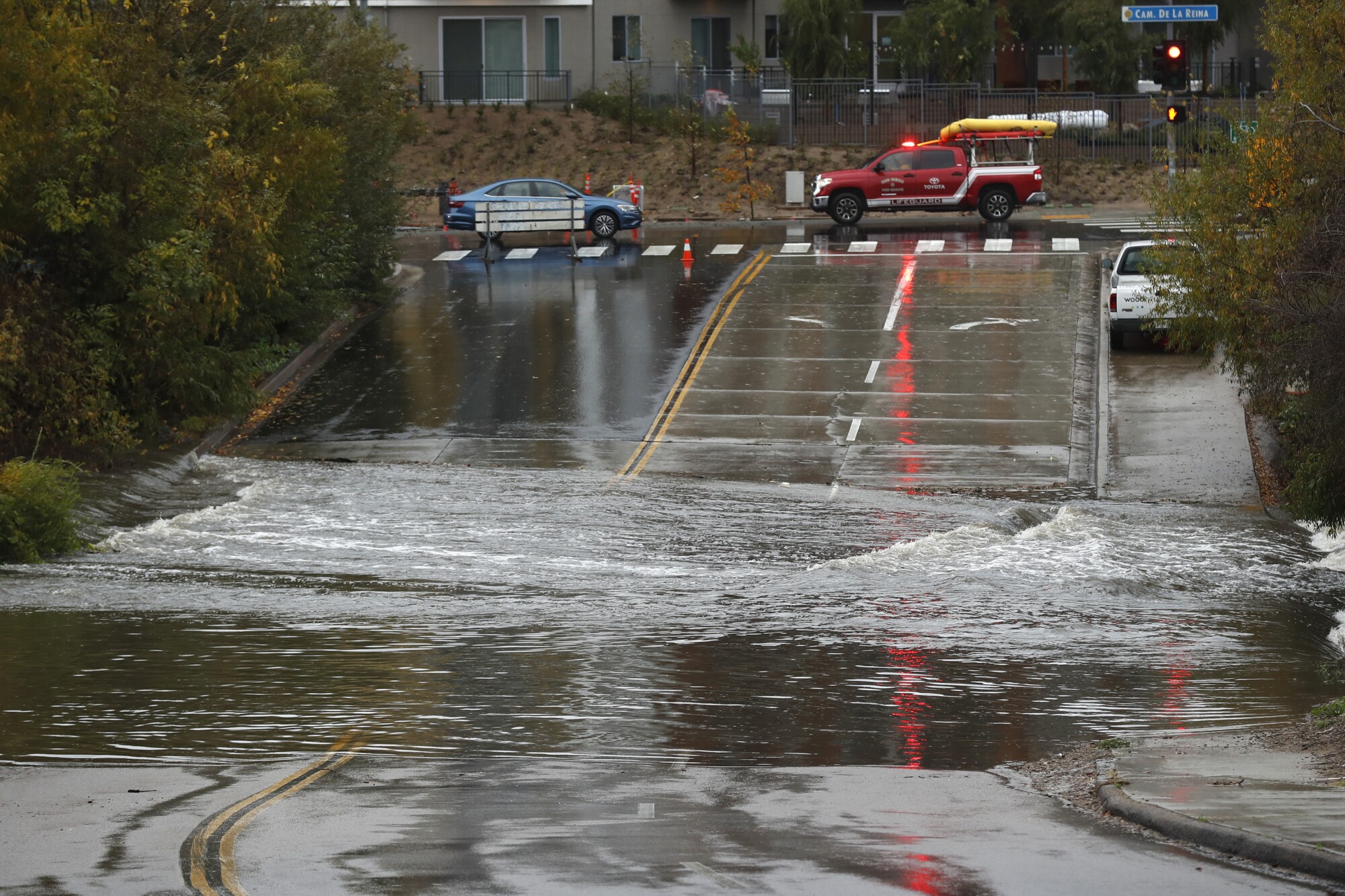 A San Diego Lifeguard swift water rescue team drives by a flooded Avenida Del Rio during a storm on Tuesday.