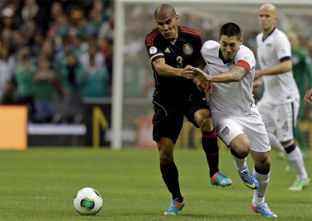 Mexico's Carlos Salcido, left, and United States captain Clint Dempsey vie for the ball during a 2014 World Cup qualifying match at the Aztec stadium in Mexico City.