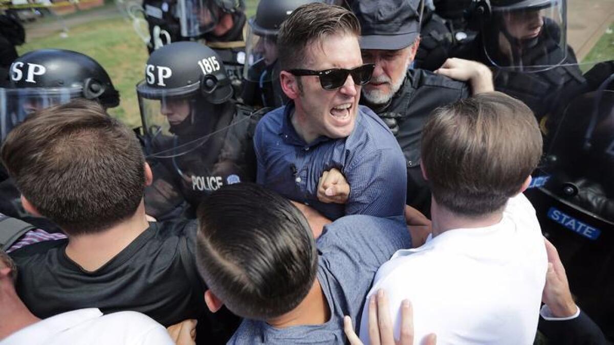 El nacionalista blanco Richard Spencer, con gafas, y sus partidarios, chocan con la policía del estado de Virginia en Lee Park, luego de que el mitin “Unite the Right” fuera declarado como reunión ilegal, el 12 de agosto pasado, en Charlottesville.