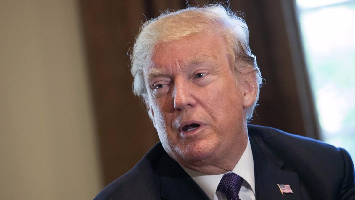 President Trump, shown during a meeting with members of the Senate Finance Committee and his economic team Wednesday, is taking criticism over his handling of condolence calls to the families of slain servicemen.