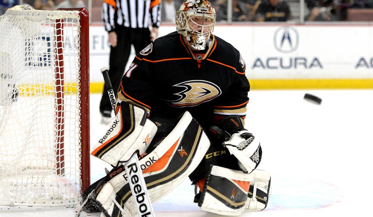 Ducks goaltender Frederik Andersen watches the puck sail toward the boards after he blocked a shot by the Canucks on Sunday.