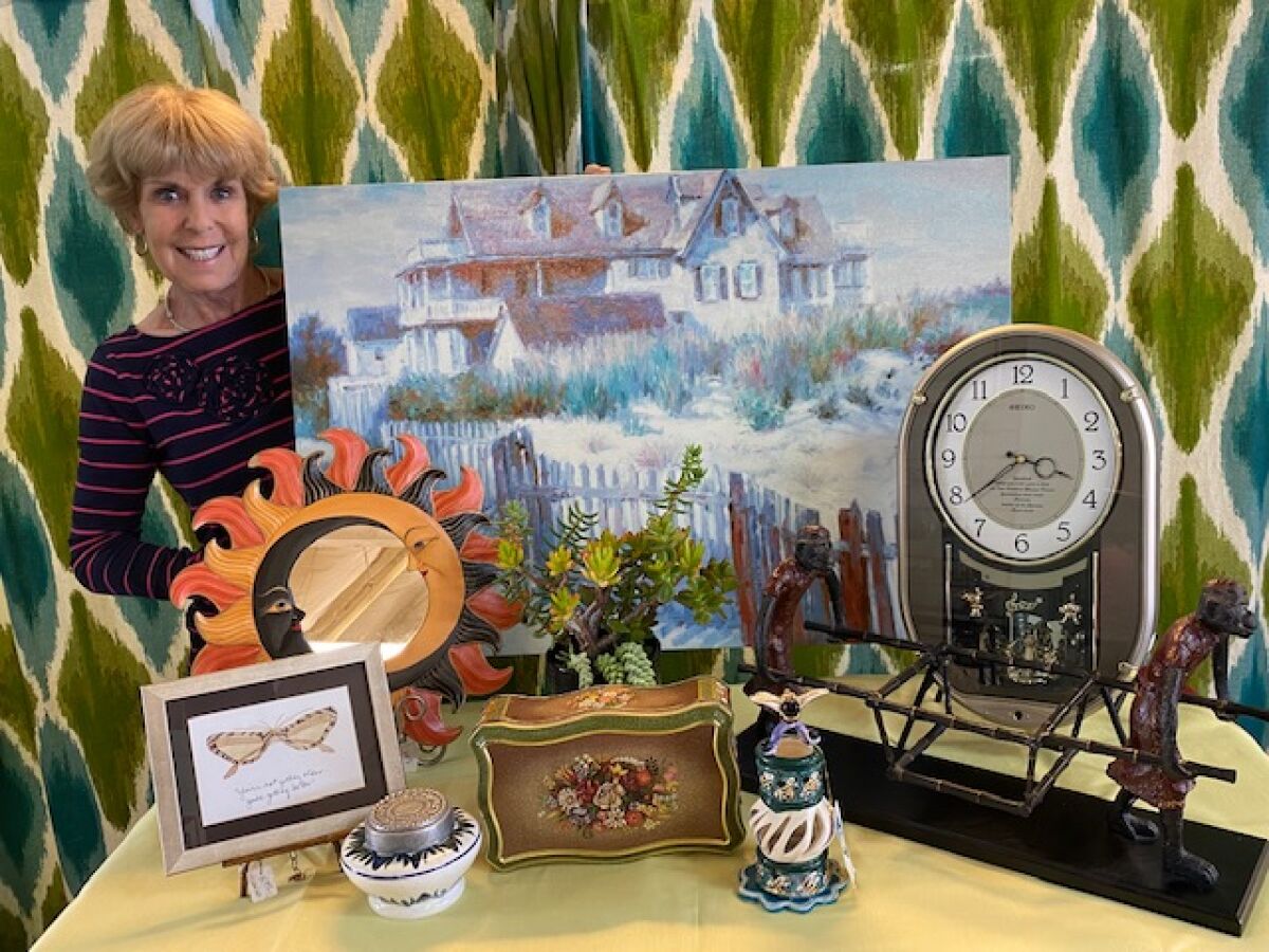 Katie Fish displays unique items for the Assistance League Thrift Shop sidewalk sale.