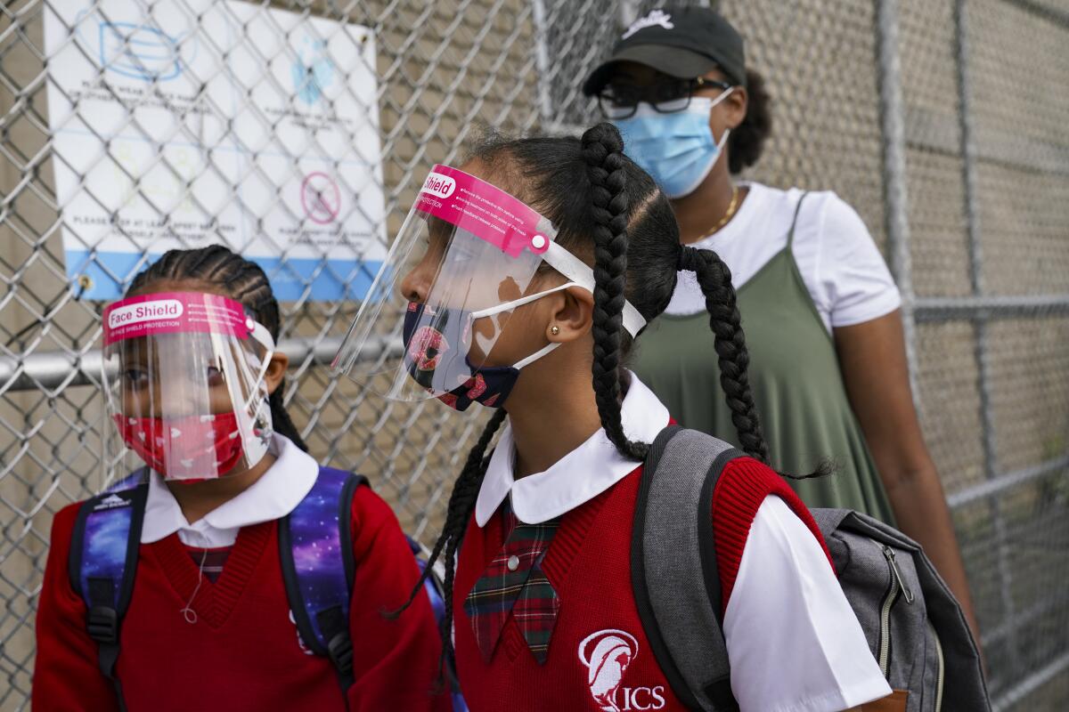 Estudiantes portan mascarillas y protecciones en una escuela en el vecindario del Bronx en la ciudad de Nueva York.