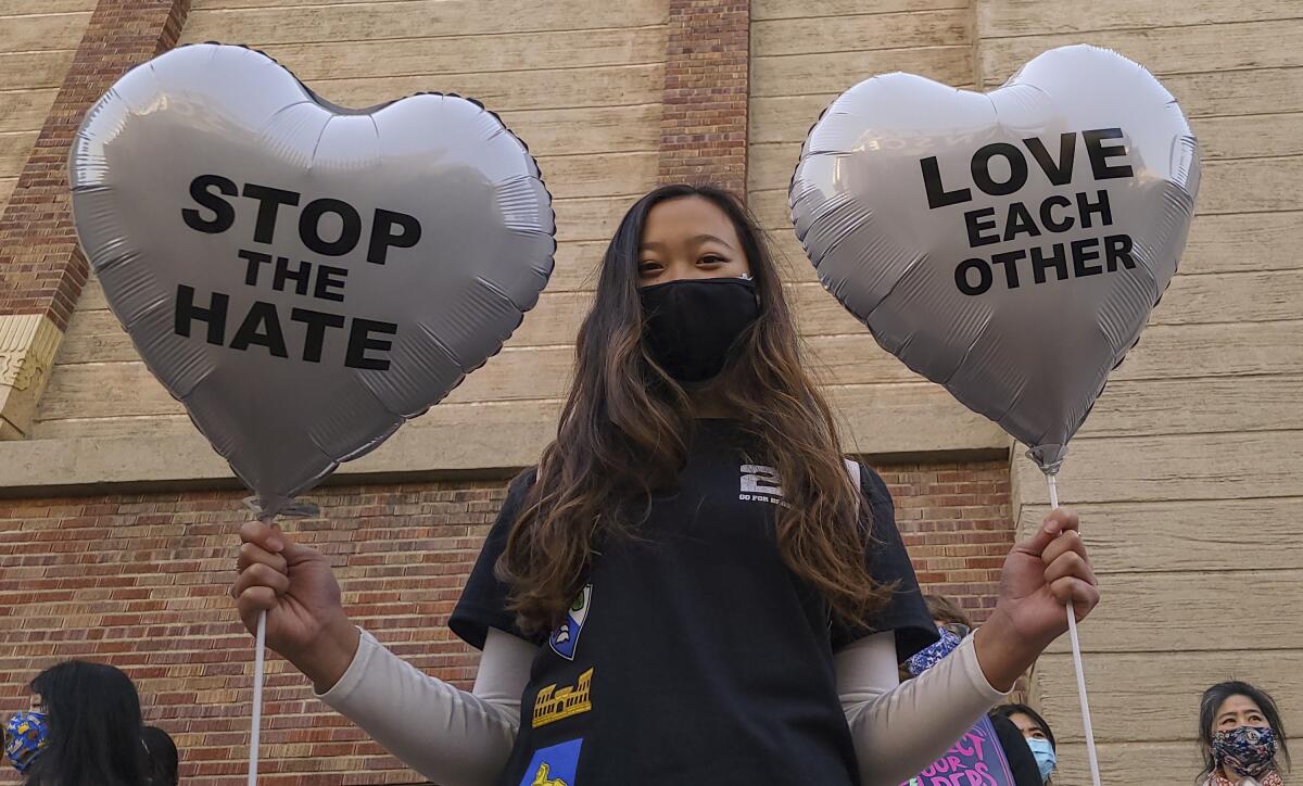 Chinese-Japanese American student Kara Chu, 18, holds a pair of heart balloons 