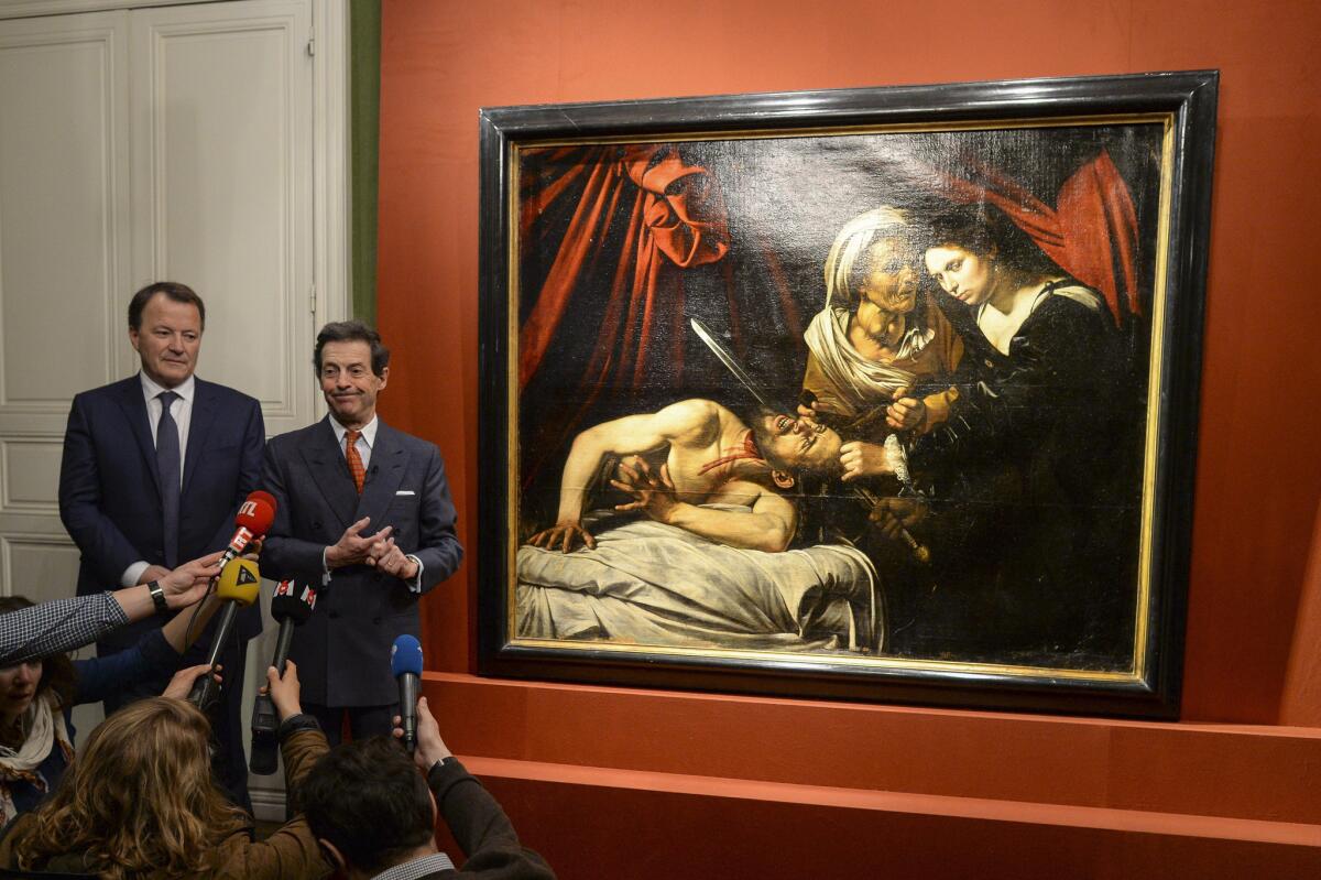 At a Tuesday news conference in Paris, art expert Eric Turquin, right, and auctioneer Marc Labarbe present a work of art that Turquin and others believe was created by Italian Baroque artist Michelangelo Merisi da Caravaggio.