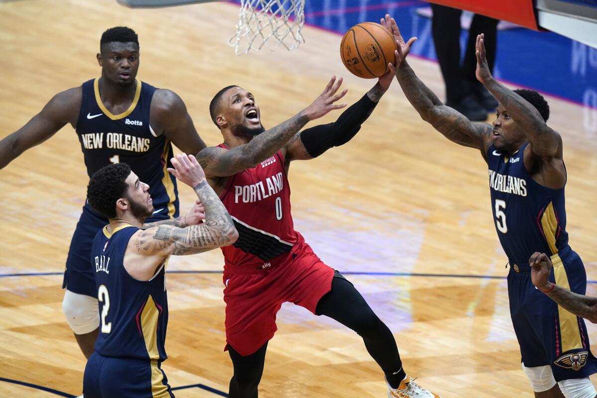 Portland Trail Blazers guard Damian Lillard goes to the basket between New Orleans Pelicans defenders.
