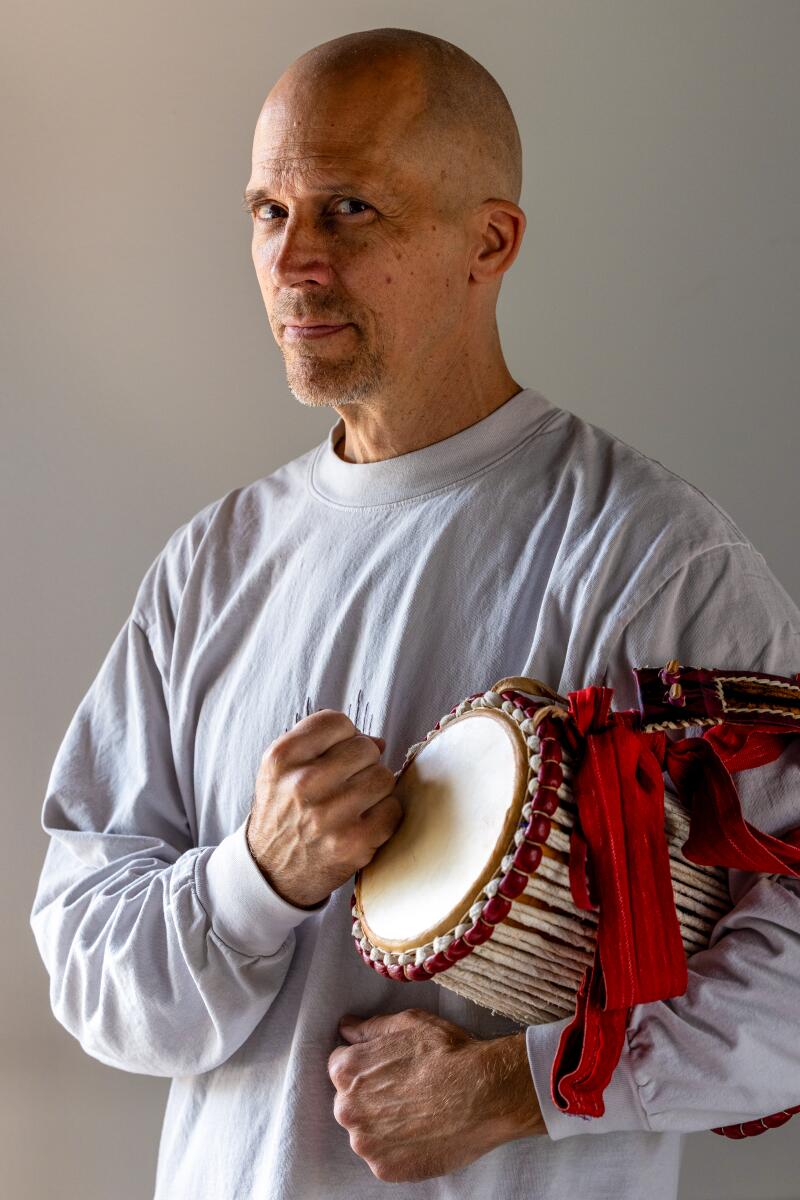 Drumboxing co-founder John Wakefield places a fist on a drum that he holds under his arm.