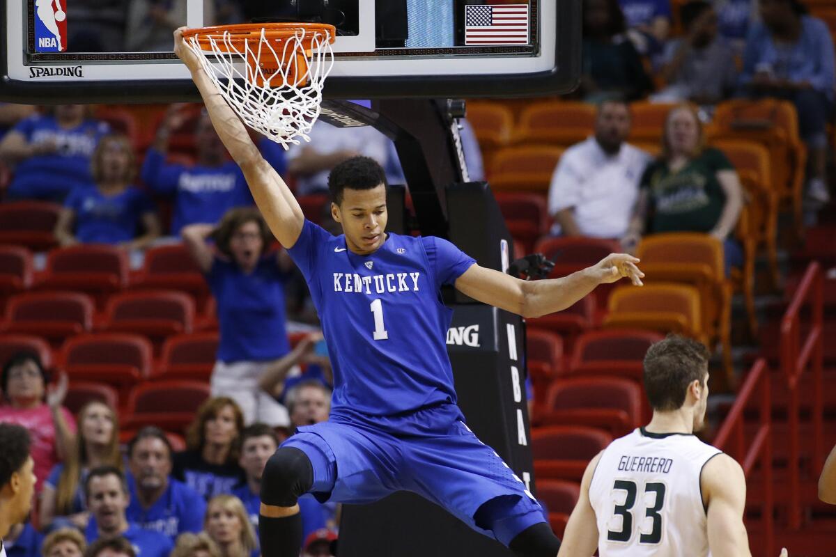 Kentucky center Skal Labissiere hangs on the basket after being fouled by South Florida.
