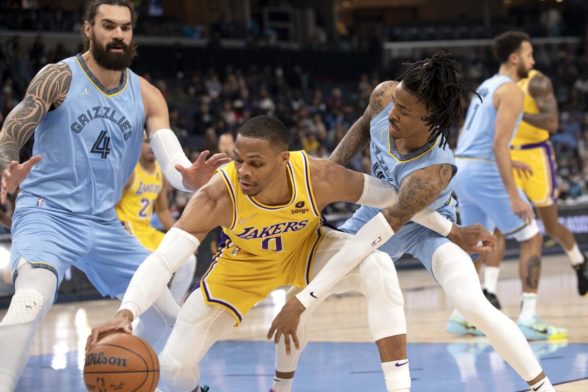 Lakers guard Russell Westbrook is defended by Memphis Grizzlies center Steven Adams and guard Ja Morant.