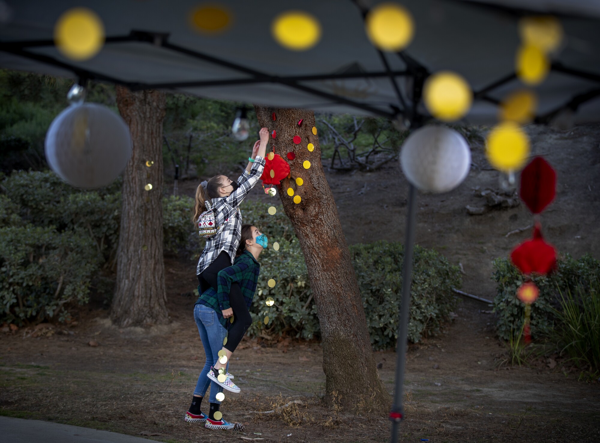 Twins Amber Day, left, and sister, Brooke, decorate a park for Lantern Festival of Hope event