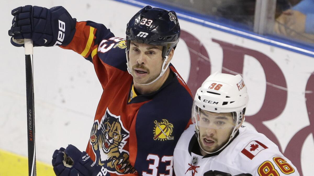 Florida Panthers defenseman Willie Mitchell, left, battles with Calgary Flames center Josh Jooris for position near the net during Florida's loss on Nov. 8.