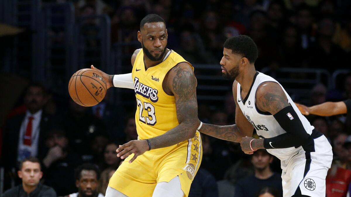 Lakers' LeBron James (23) is defended by Clippers' Paul George on Dec. 25, 2019, at Staples Center.