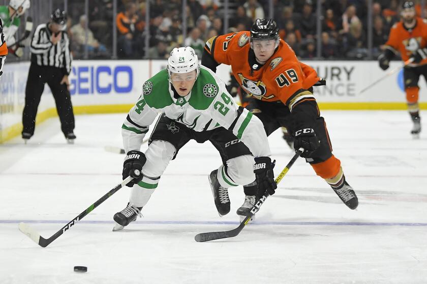 Dallas Stars left wing Roope Hintz, left, and Anaheim Ducks left wing Max Jones reach for the puck during the second period of an NHL hockey game Thursday, Jan. 9, 2020, in Anaheim, Calif. (AP Photo/Mark J. Terrill)