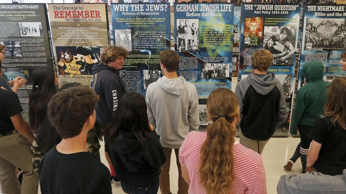 Ninth-graders from teacher Jillian Jontig’s English class view the exhibit “The Courage to Remember: The Holocaust 1933-1945” at Huntington Beach High School on Monday. The exhibit features more than 200 photos.