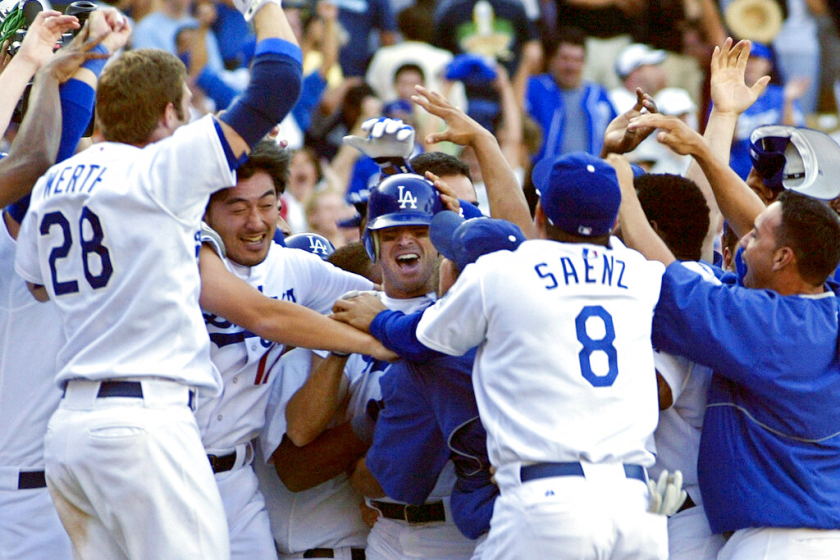 Dodgers' Steve Finley, center with helmet, celebrates with teammates after hitting a grand slam.