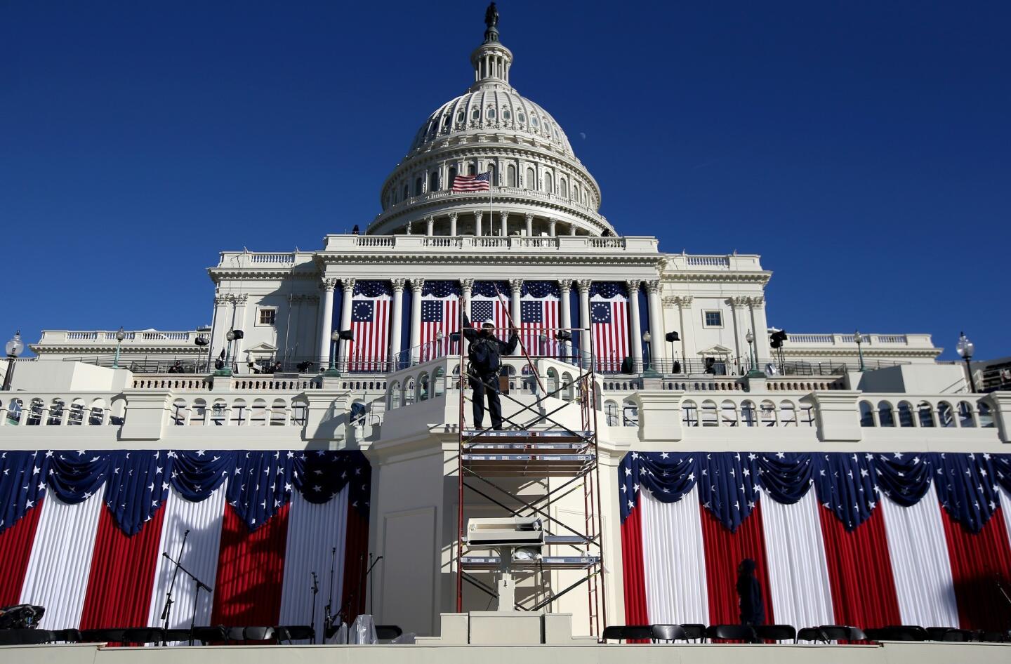 A worker removes scaffolding at the Capitol as preparations continued for Monday's ceremonies, expected to draw more than a half-million people.