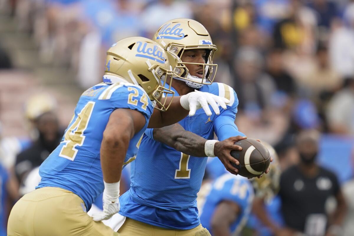 UCLA quarterback Dorian Thompson-Robinson hands off to running back Zach Charbonnet.