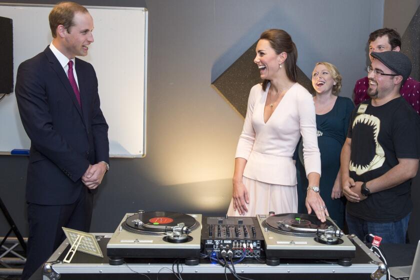 Catherine, Duchess of Cambridge and Prince William, Duke of Cambridge laugh as they are shown how to play on DJ decks at the Northern Sound System, a youth community center in a suburb of Adelaide, Australia.