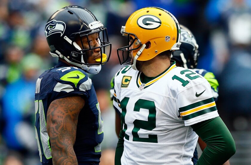 Kam Chancellor of the Seattle Seahawks and Aaron Rodgers of the Green Bay Packers exchange words during the first half of the 2015 NFC Championship game at CenturyLink Field in Seattle.