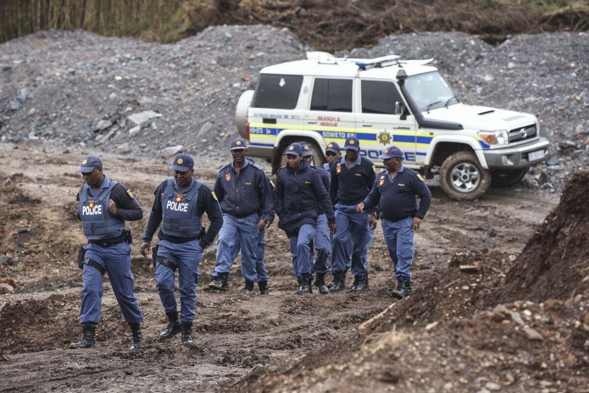 South African police investigate at the scene where more than 20 bodies, suspected of being illegal miners, were found near an active mine in Krugersdorp, South Africa, Thursday, Nov. 3, 2022. Police suspect that the bodies were moved to where they were found at a privately-owned mine. The grim discovery is the latest in a series of incidents related to illegal mining in the Krugersdorp area. (AP Photo)
