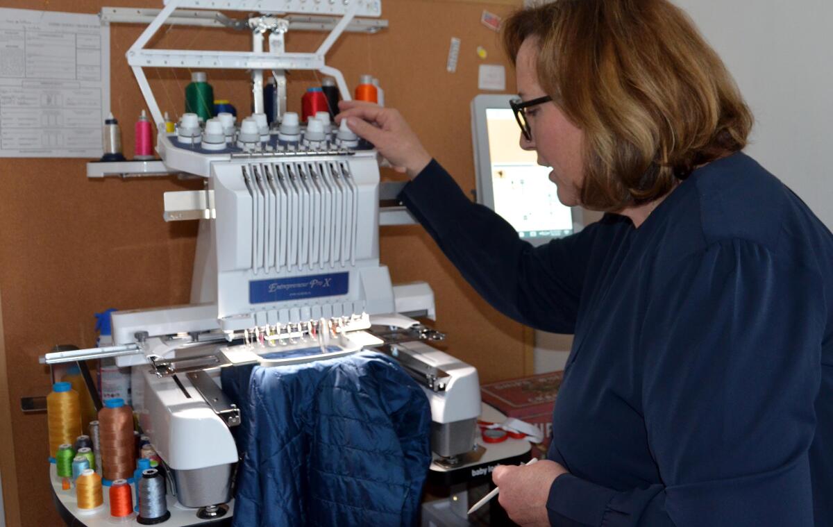 Michele McCormack adjusts her commercial embroidery machine.