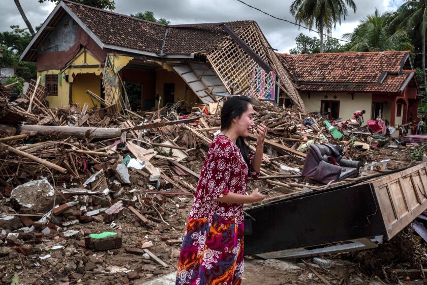 A distraught woman looks for her belongings at a house destroyed by the tsunami in Indonesia.