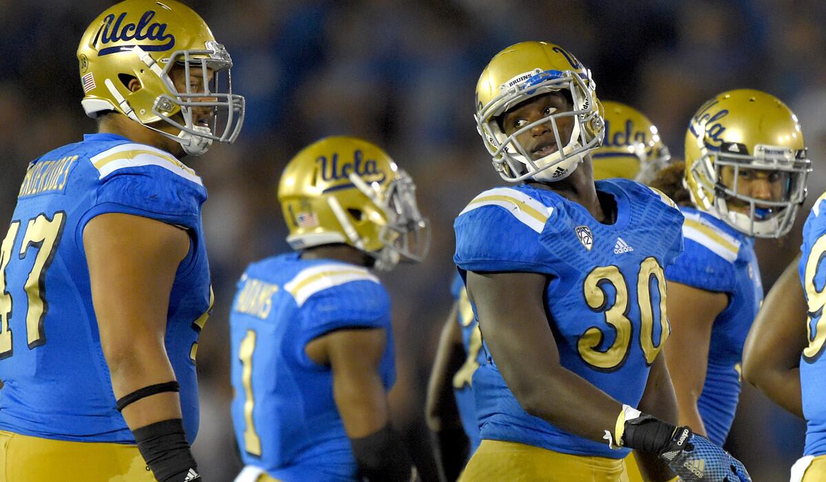 UCLA linebacker Myles Jack (30) and defensive lineman Eddie Vanderdoes (47) know that a better tackling will lead to a winning formula.