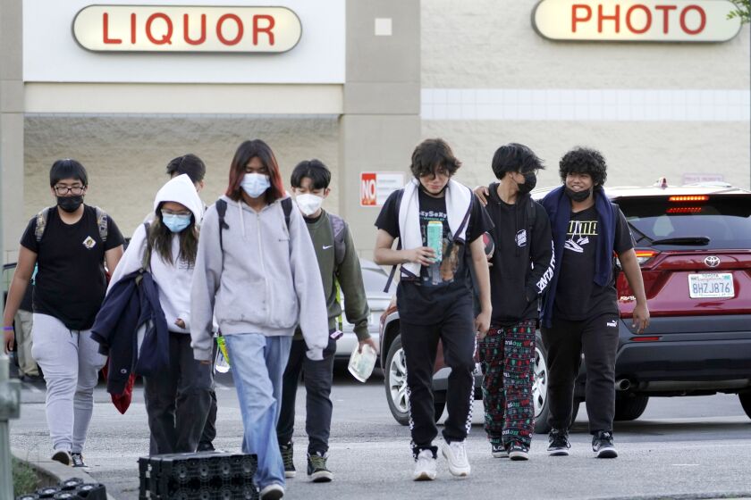 High school students wear mask outdoors downtown Los Angeles Friday, Feb. 18, 2022. 
