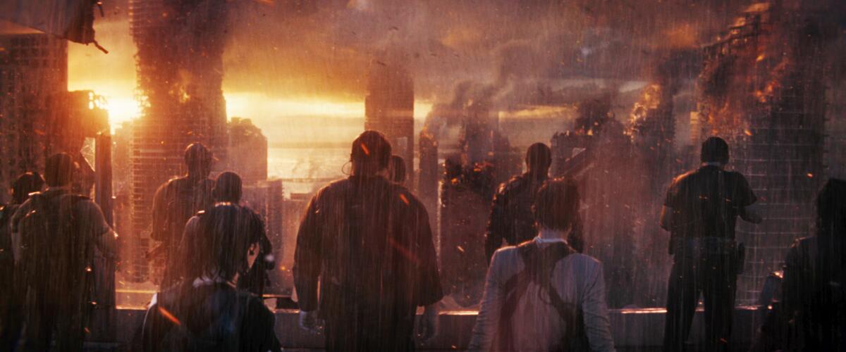 People watch high-rise buildings burn from a rooftop in the movie “The Tomorrow War.”