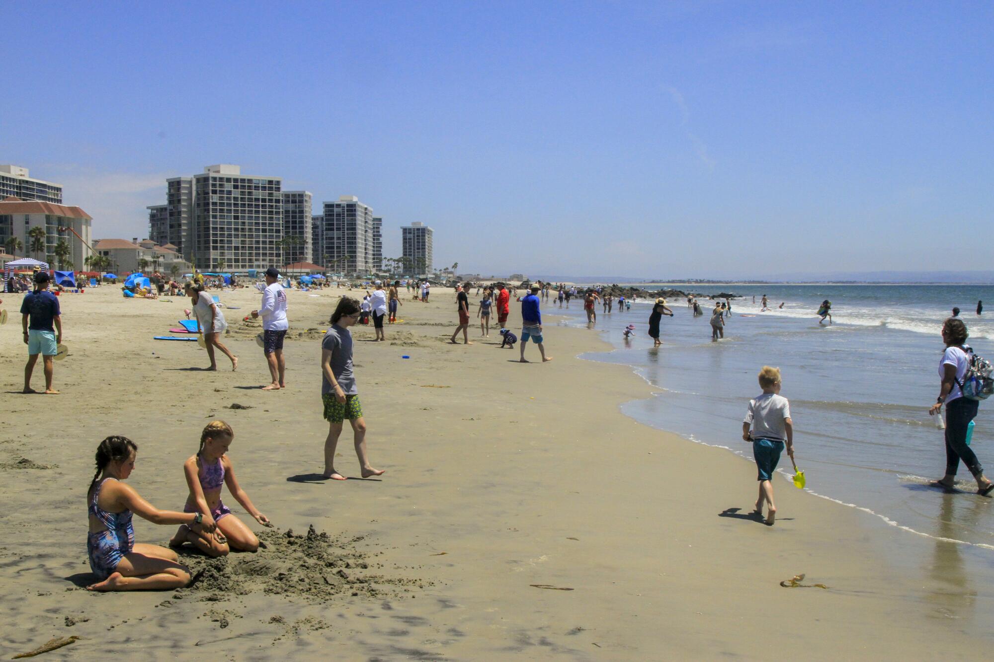 Children play on the beach in front of the Hotel del Coronado.