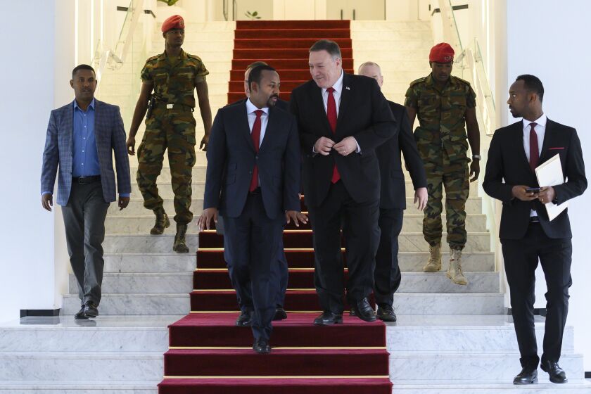 FILE - In this Tuesday, Feb. 18, 2020 file photo, U.S. Secretary of State Mike Pompeo, center right, walks with Ethiopia's Prime Minister Abiy Ahmed, center-left, after meeting at the Prime Minister's office in Addis Ababa. The State Department said Wednesday, Sept. 2, 2020 that on the guidance of President Donald Trump the U.S. is suspending some aid to Ethiopia over the "lack of progress" in talks with Egypt and Sudan over a massive, disputed dam project which Egypt has called an existential threat and worries will reduce the country's share of Nile waters. (Andrew Caballero-Reynolds/Pool via AP, File)