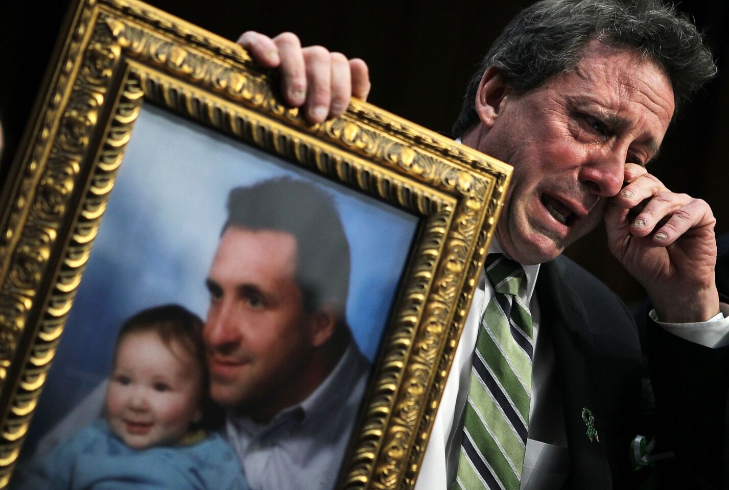 Neil Heslin, father of 6-year-old Sandy Hook Elementary School shooting victim Jesse Lewis, wipes away tears as he testifies during a hearing before the Senate Judiciary Committee on Capitol Hill.